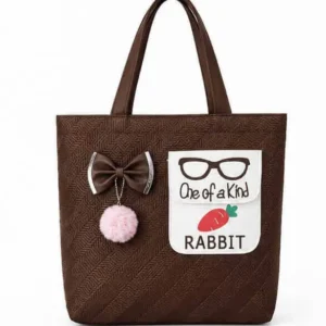 Front view of Sabuj Hub coffee brown textured handbag with bow, pompom, and rabbit carrot pocket