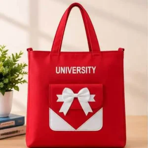 Front view of Sabuj Hub red canvas tote bag featuring UNIVERSITY text print and white bow pocket detai